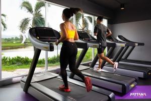 two people running on a treadmill in a gym at Pattana Sports Resort in Si Racha