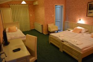 a hotel room with two beds and a desk at Motel Most in Ljubuški