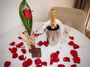 una mesa con una botella de champán y rosas rojas en Bartolomeu Beach Apartments, en Oporto