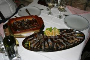 a table with a plate of oysters and a bottle of wine at Motel Most in Ljubuški