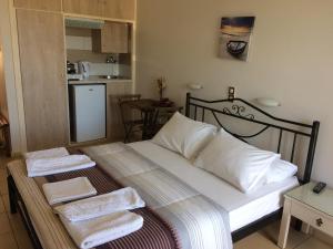 a bedroom with a bed with towels on it at Isidora Hotel in Agia Marina Aegina
