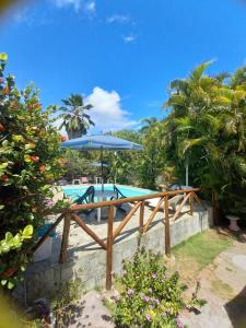 a pool with a picnic table and an umbrella at Okakoaras Hotel in Maria Farinha