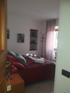um quarto com uma cama com lençóis vermelhos e uma janela em Affittacamere Da Luca em Bonassola
