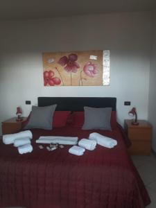 een slaapkamer met een rood bed en handdoeken erop bij Affittacamere Da Luca in Bonassola