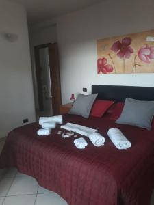 a bedroom with a red bed with towels on it at Affittacamere Da Luca in Bonassola