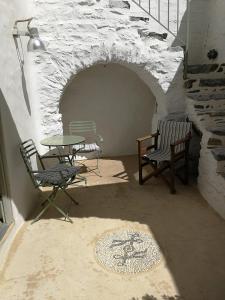 Habitación con mesa y sillas en una pared de ladrillo. en Chora Elegant Traditional House, en Amorgós