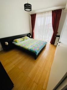 1 dormitorio con 1 cama y suelo de madera en Apartment Richy Brasov, en Brasov