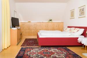 Habitación con cama, TV y alfombra. en Gästehaus Plank, en Graz