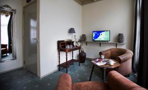 斯騰韋克的住宿－Stadslogement De Oude Smidse Steenwijk，客厅配有两张沙发和一台电视