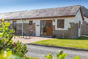 ein Cottage mit einem Tisch und Stühlen davor in der Unterkunft Tryfan Holiday Cottage in Llanfairpwllgwyngyll