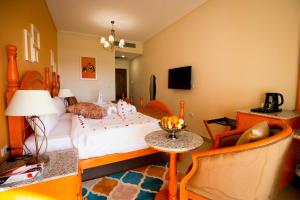 a bedroom with a bed and a table and a chair at Holy Family Hotel in Jabal aţ Ţayr