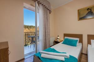 a bedroom with a bed and a balcony at Hotel Citadel in Skhidnitsa +100 photos