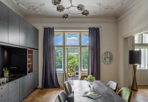 ein Esszimmer mit einem Tisch und einem großen Fenster in der Unterkunft MN6 Luxury Suites by Adrez in Prag