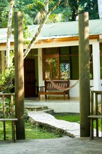 a house with a hammock in front of it at Hotel Jaguar Inn Tikal in Tikal