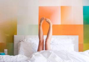 une personne qui se couche au lit avec ses jambes dans l'air dans l'établissement Les Béthunoises Centre Grand-Place - Spa et Sauna, à Béthune