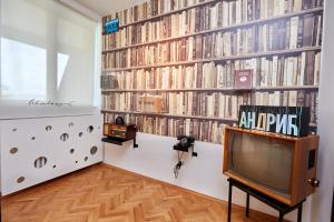 a tv in a room with a wall of books at Hotel Moravica in Soko Banja