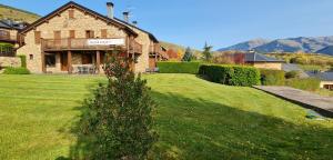 a house on a lawn with a tree in the yard at Casa con encanto, jardín, vistas y piscina in Estavar