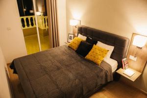 1 dormitorio con 1 cama grande con almohadas amarillas en Aparthotel Costa Blanca en Torrevieja