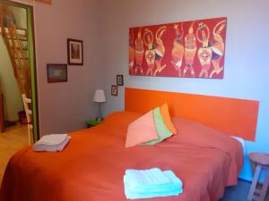 een slaapkamer met een oranje bed met 2 handdoeken erop bij San Gregorio Studio in Napels