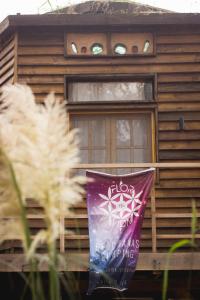 ein Holzhaus mit einem Banner davor in der Unterkunft Flor de Vida Geocabañas - Casa Gala in La Esmeralda