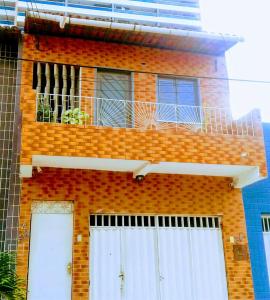 ein Backsteingebäude mit Balkon darüber in der Unterkunft Léa Pousada in Fortaleza