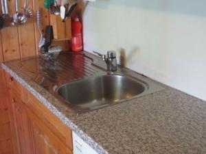 a kitchen counter with a stainless steel sink at Chalet Alpina in Riederalp