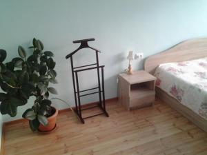 a room with a bed and a plant and a night stand at Lori Apartment in Narva