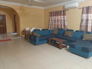 sala de estar con sofá azul y mesa en Villa Chambre A climatisée douche Cuisine salon en Bamako