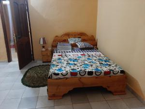 1 dormitorio con cama de madera en una habitación en Villa Chambre A climatisée douche Cuisine salon en Bamako