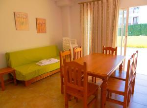 a dining room with a table and a couch at Anamar Kione Rentals in Alcossebre