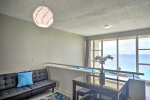 Rincon Penthouse Steps to Private Beach Oasis! في رينكون: غرفة معيشة مع أريكة وطاولة زجاجية