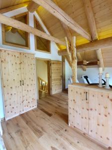a large room with wooden ceilings and wooden doors at Almzauber Chalets Hochrindl in Hochrindl