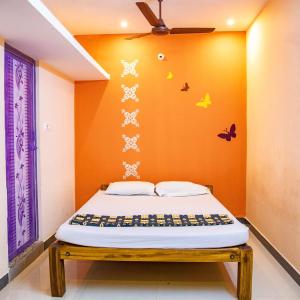 - un lit dans une chambre avec des papillons sur le mur dans l'établissement sea house, à Pondichéry