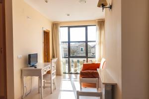 a room with a desk with a computer and a window at Hotel Rural La Consulta De Isar in Isar