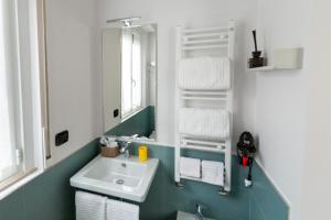 un bagno con lavandino, specchio e asciugamani di Il giardino di Fiorina a Novate Milanese Altre 26 foto