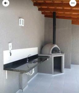 een keuken met een wastafel en een pizza-oven bij Apartamento UBATUBA perto das Praias Grande e Tenório in Ubatuba