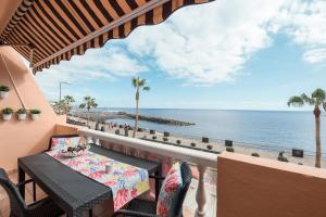 een tafel en stoelen op een balkon met uitzicht op de oceaan bij Apartamento junto al Mar in Araya