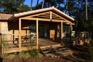 a small cabin with a porch and a deck at Chalet la lande in Ondres