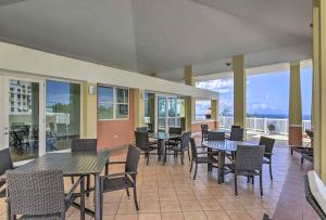 Un patio con mesas y sillas y el mar. en Heavenly Aguadilla Condo with Infinity Pool and Views!, en Aguadilla