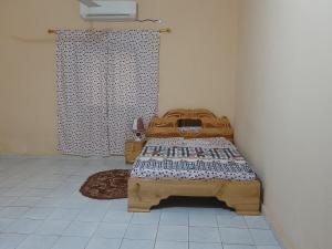 a bedroom with a wooden bed in a room at Villa Chambre B climatisée douche Cuisine salon in Bamako