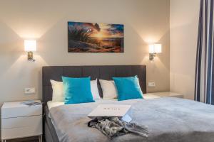 a bedroom with a large bed with blue pillows at Terrassenwohnung "Kliffgarten" - Oase am Haff in Garz-Usedom