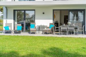 a patio with blue and gray chairs and a table at Terrassenwohnung "Kliffgarten" - Oase am Haff in Garz-Usedom +58 photos