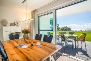 a kitchen and dining room with a wooden table at Terrassenwohnung "Kliffgarten" - Oase am Haff in Garz-Usedom