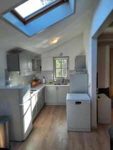 uma cozinha com armários brancos e uma clarabóia em Emmy's Cottage em Schoorl