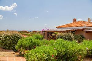 a house with a garden with bushes and flowers at Residence Hotel Lu Nibareddu in San Teodoro