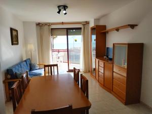 comedor y sala de estar con mesa y TV en Da Vinci Vista Mar Superior Orangecosta, en Peñíscola