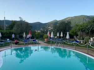 ein großer Pool mit Stühlen und Sonnenschirmen in der Unterkunft Rabbit in Agerola