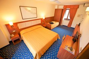 a hotel room with a bedroom with two beds at Hotel Benaco in Nago-Torbole