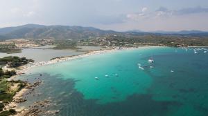 een luchtzicht op een strand met boten in het water bij Residence Hotel Lu Nibareddu in San Teodoro