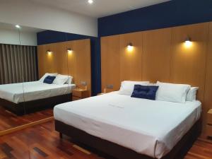 um quarto de hotel com duas camas e paredes azuis em Hotel Dunas d'Ovar em Ovar